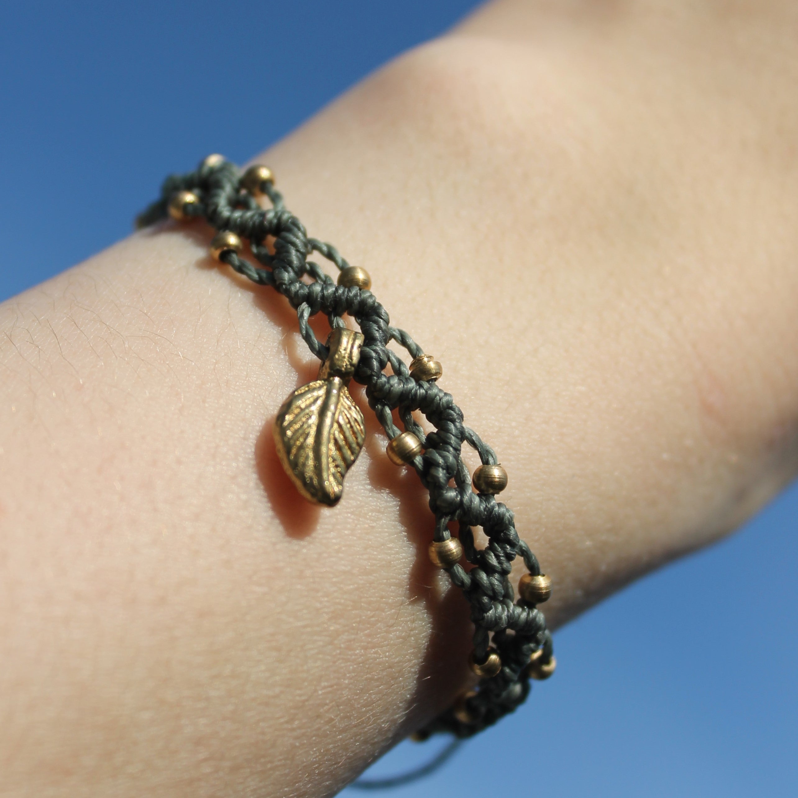 LUANA Makramee Armband dunkelgrün mit Messinganhänger goldfarben